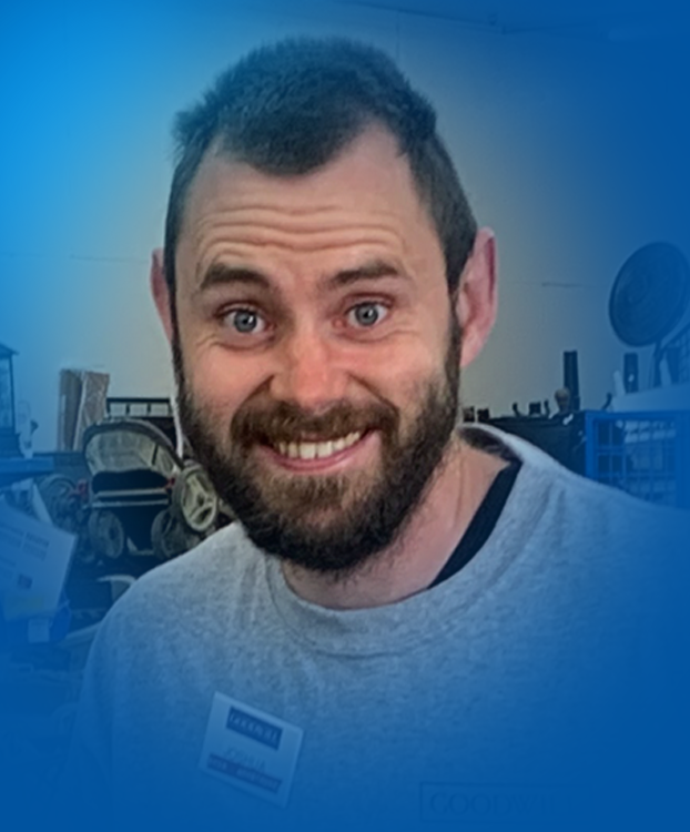 Young man smiling in a Goodwill store.