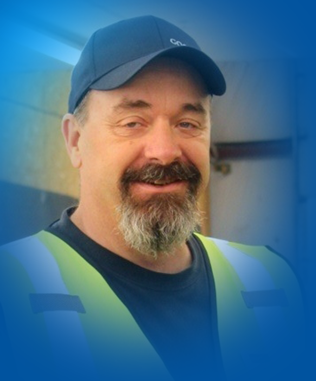 Rodney smiling while standing in front of a Goodwill sign.