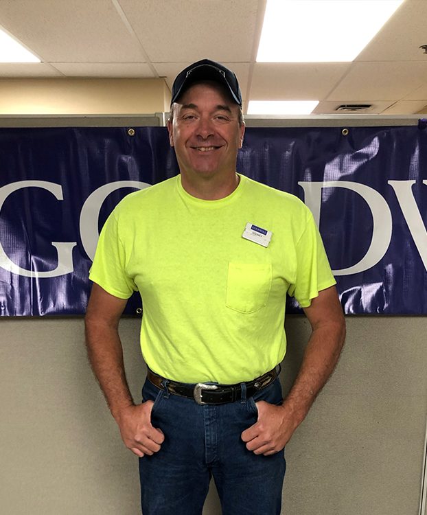 Rodney smiling while standing in front of a Goodwill sign.