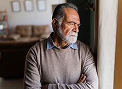 Elderly lonely man looking out a window